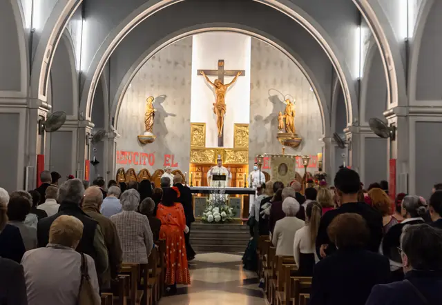 Fieles y hermanos participando en un culto ante el altar de la parroquia